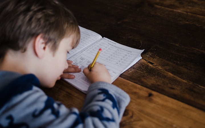 A young boy struggling to concentrate over a school exercise book