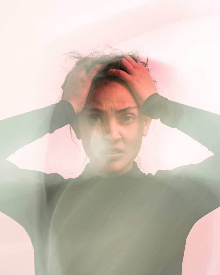 A woman holding her head, photographed with motion blur