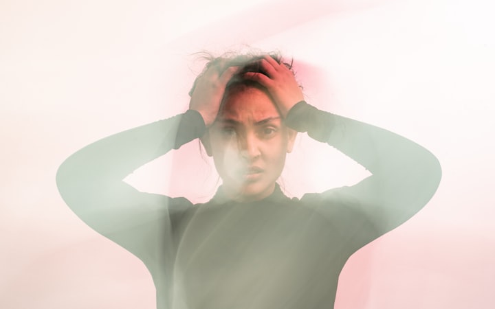 A woman holding her head, photographed with motion blur