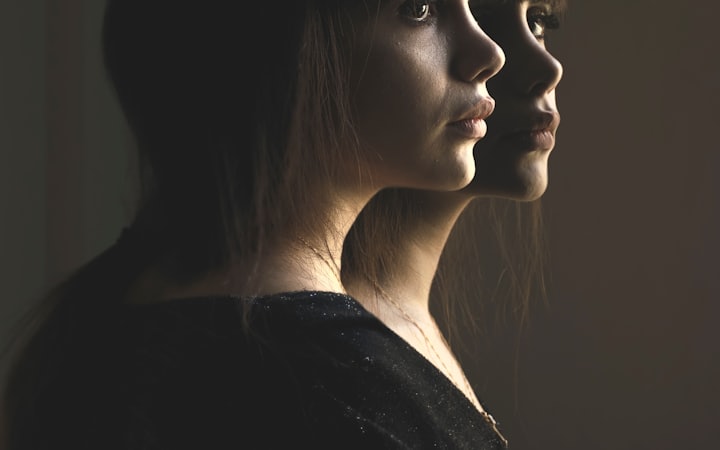 A double-exposure portrait showing the same face twice, in light and in shadow