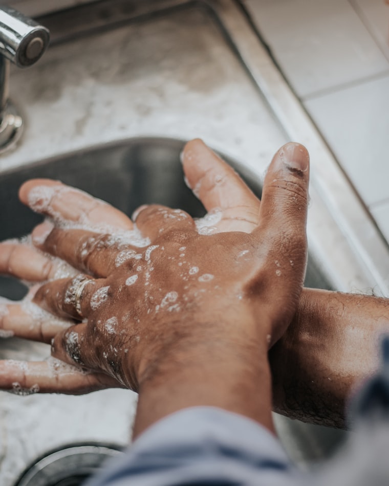 Hands being washed repeatedly with soap under a running tap