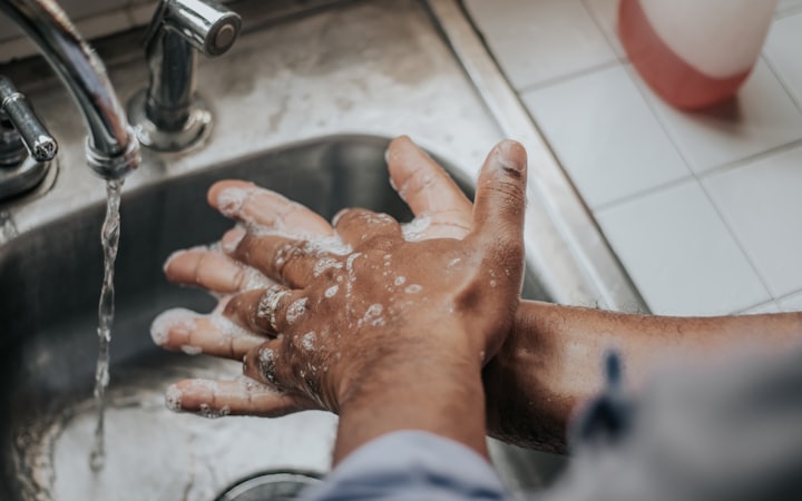 Hands being washed repeatedly with soap under a running tap